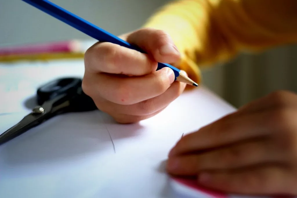 Student writing on a clean desk